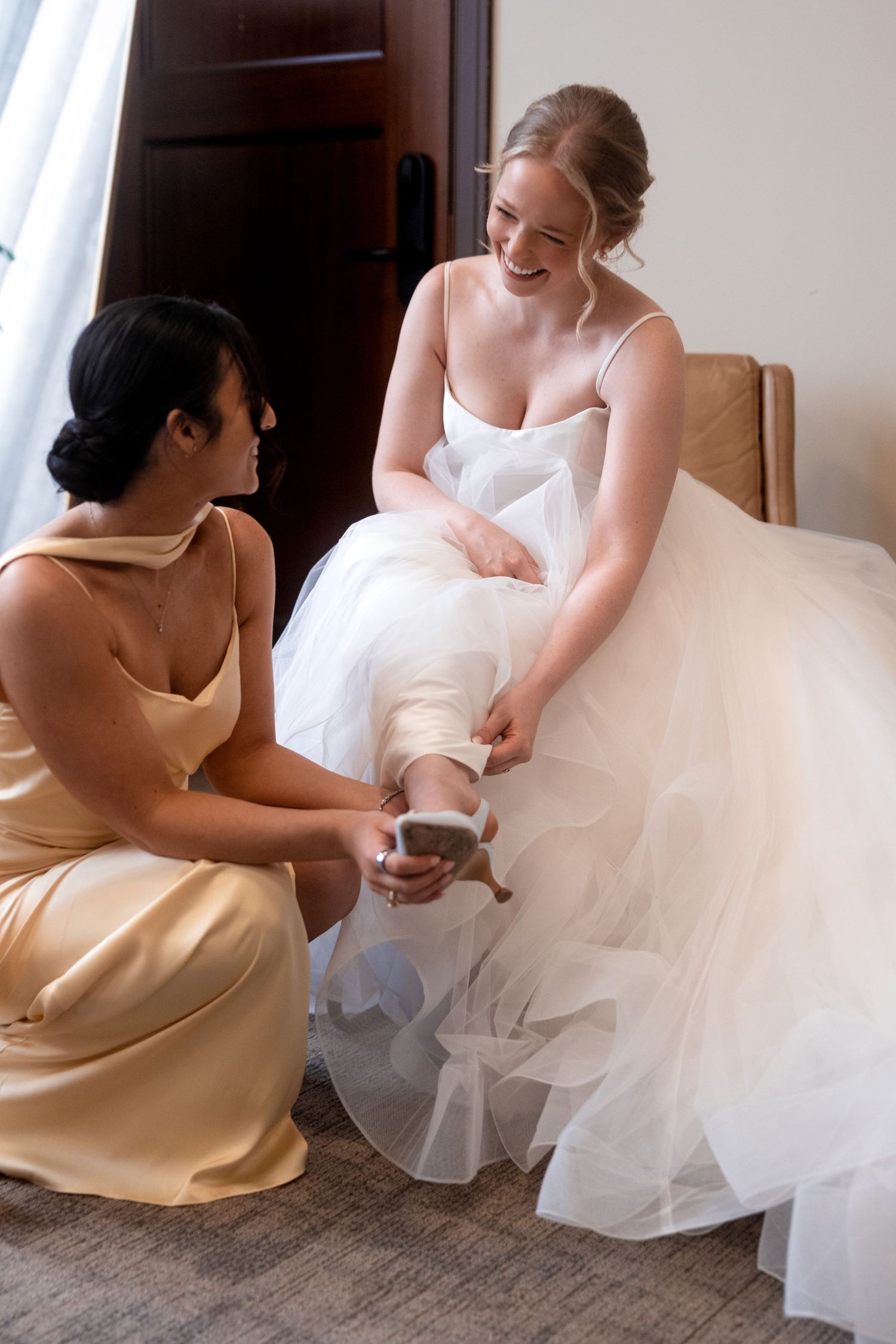Wedding dress preparation scene with tulle skirt adjustments indoors.