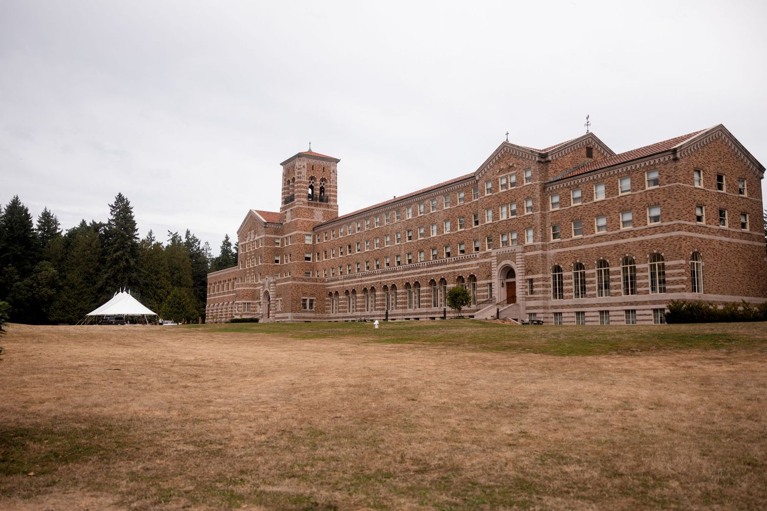 Panoramic view of a large brick monastery or church building complex on a hillside.