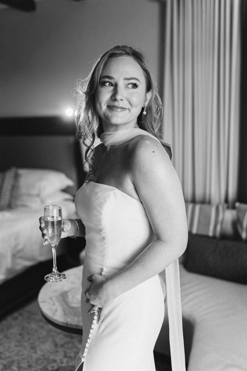 Black and white portrait of bride in a strapless white wedding dress posing elegantly in an indoor setting.
UNICO 2087 Wedding photographer