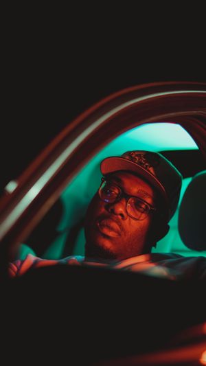 Car interior lit by teal ambient lighting showing driver's side profile.
