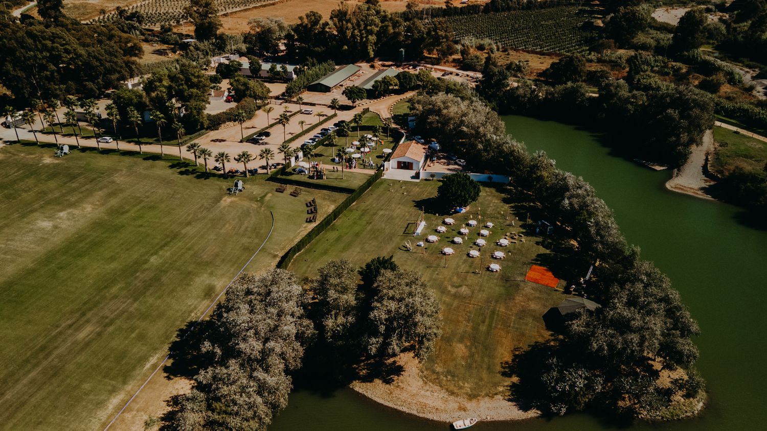 Aerial view of a rural event venue with sprawling lawns, reception buildings, and mature trees surrounding the property.