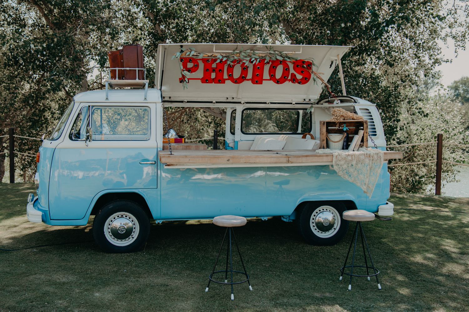 Vintage blue Volkswagen van converted into a photo booth with 'PHOTOS' sign on top.
