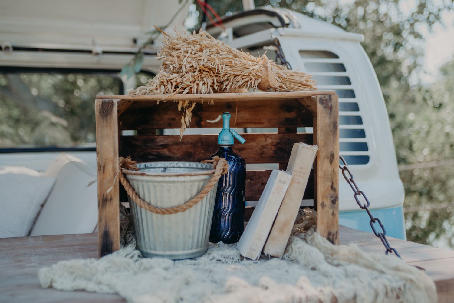 Rustic wedding decor featuring hay bales and vintage buckets in the back of an old vehicle.