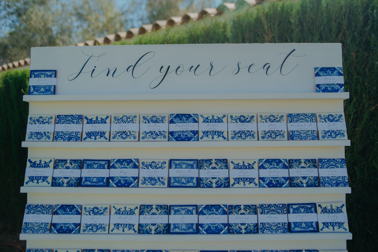 A blue and white seating chart display with elegant calligraphy for wedding guests.