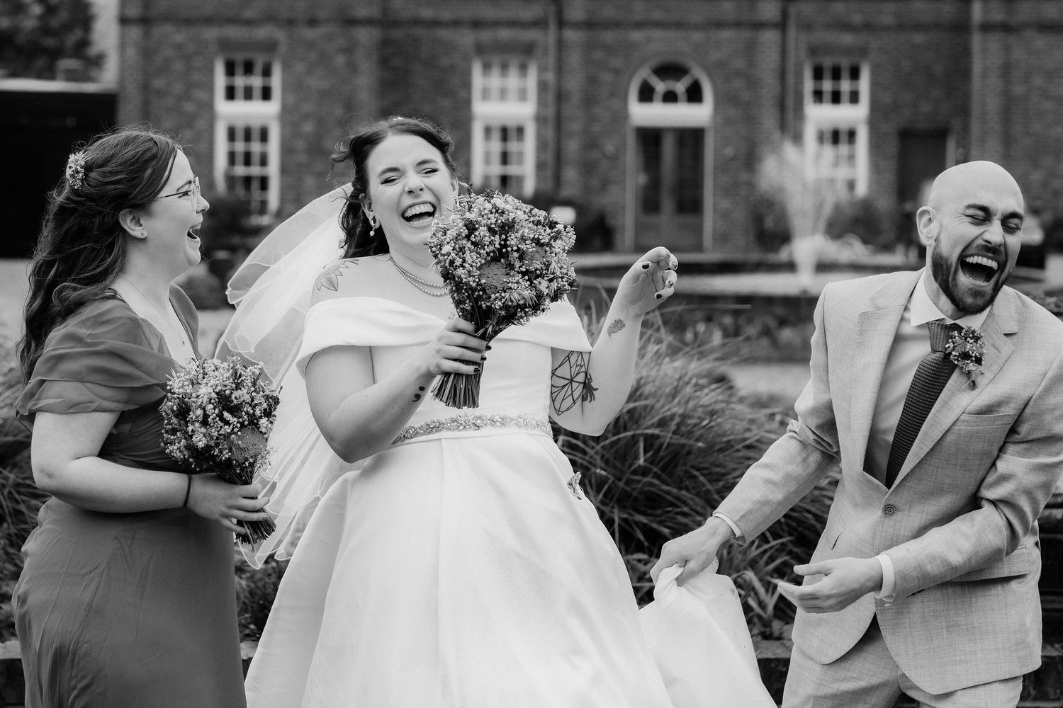 A wedding party laughing outside a brick London building