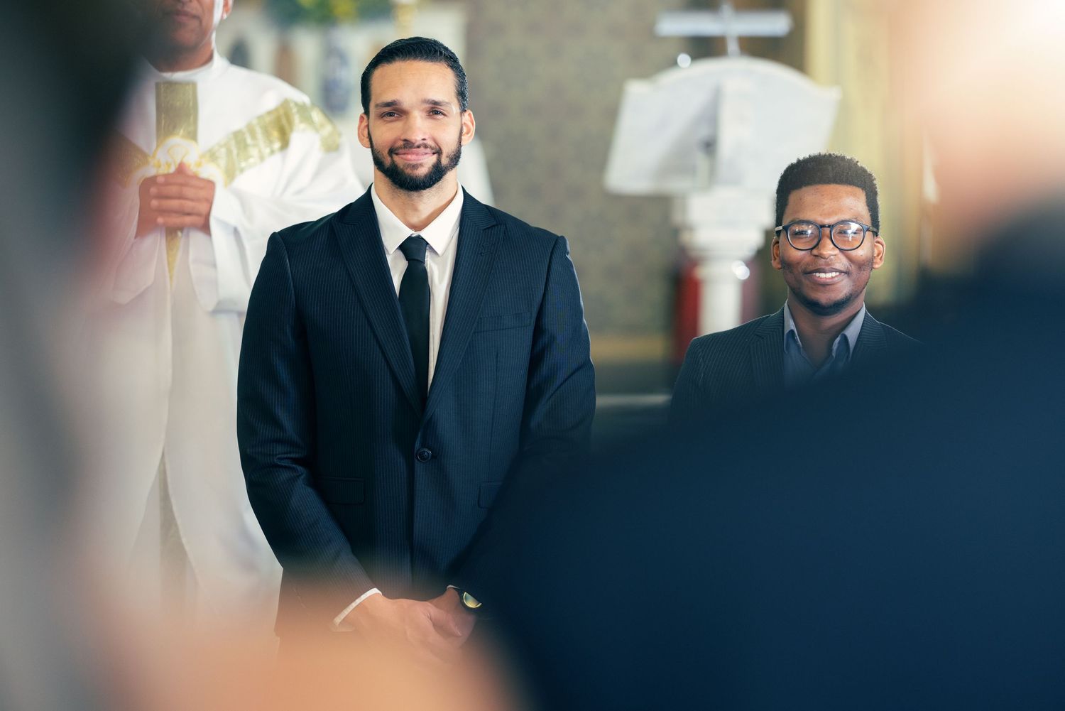 Two businessmen in formal attire stand together at what appears to be a professional event or gathering.