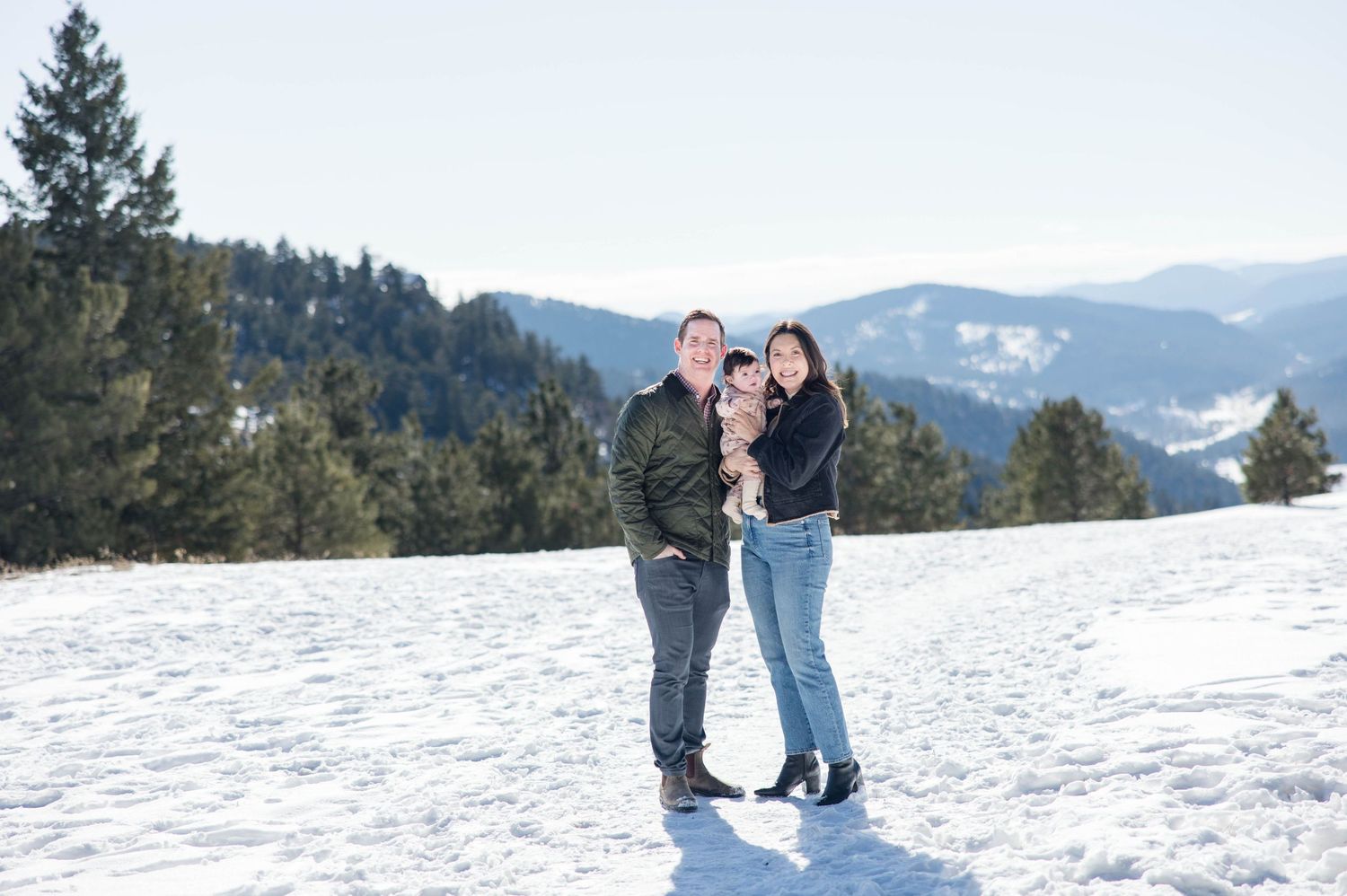 Mother and father with baby in the snow mountains of Colorado