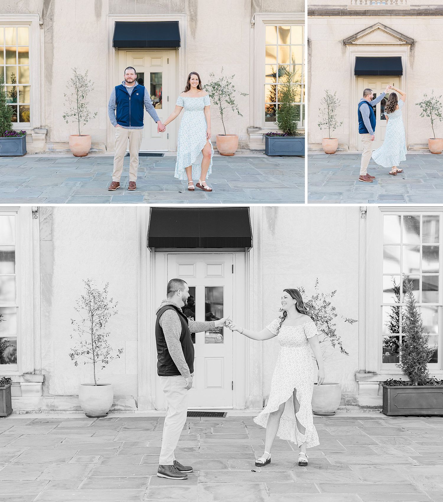 Two people pose together against a white building exterior with potted plants and black awnings in an engagement session.
