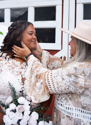 A series of four progressive photos showing a tender embrace between two people in white lace clothing.