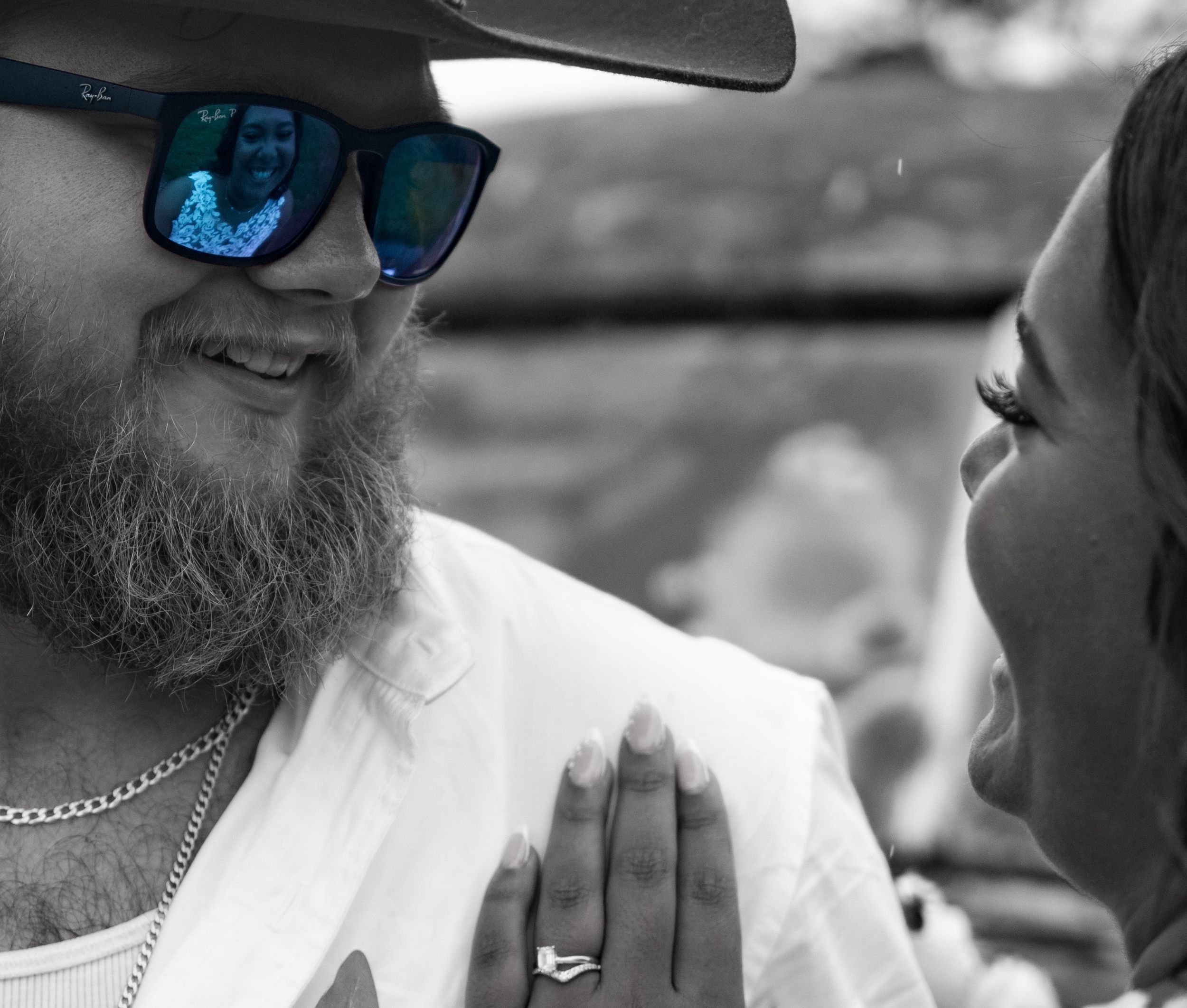 Black and white close-up photo showing sunglasses and casual attire at an outdoor gathering.