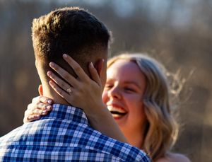 A couple embraces outdoors in a romantic moment during golden hour lighting.