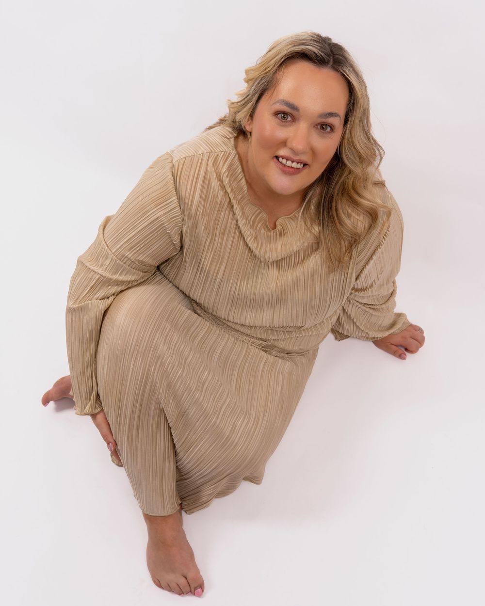 A woman in a beige ribbed turtleneck sweater poses playfully in a four-image collage against a white background.