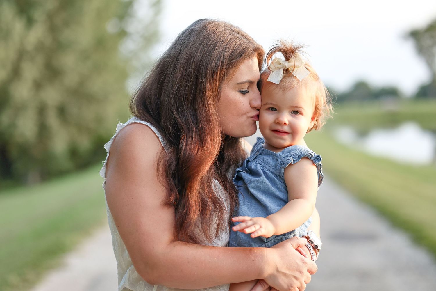 Springfield, IL family photographer captures a mom kissing her baby's cheek during a family session in Central, IL