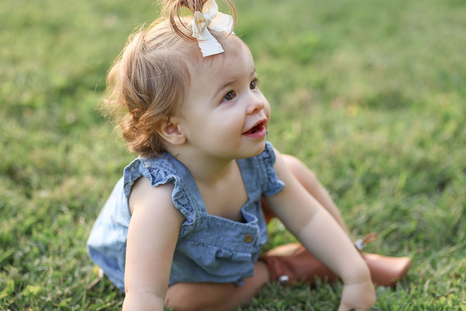 Springfield, IL family photographer captures a young toddler sitting on grass during a family session in Central, IL