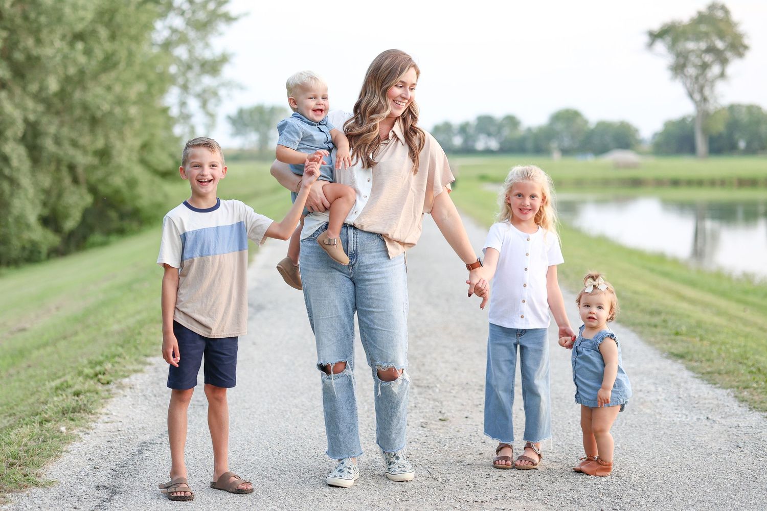 Springfield, IL family photographer captures an aunt holding nieces and nephews' hands during a family session in Central, IL