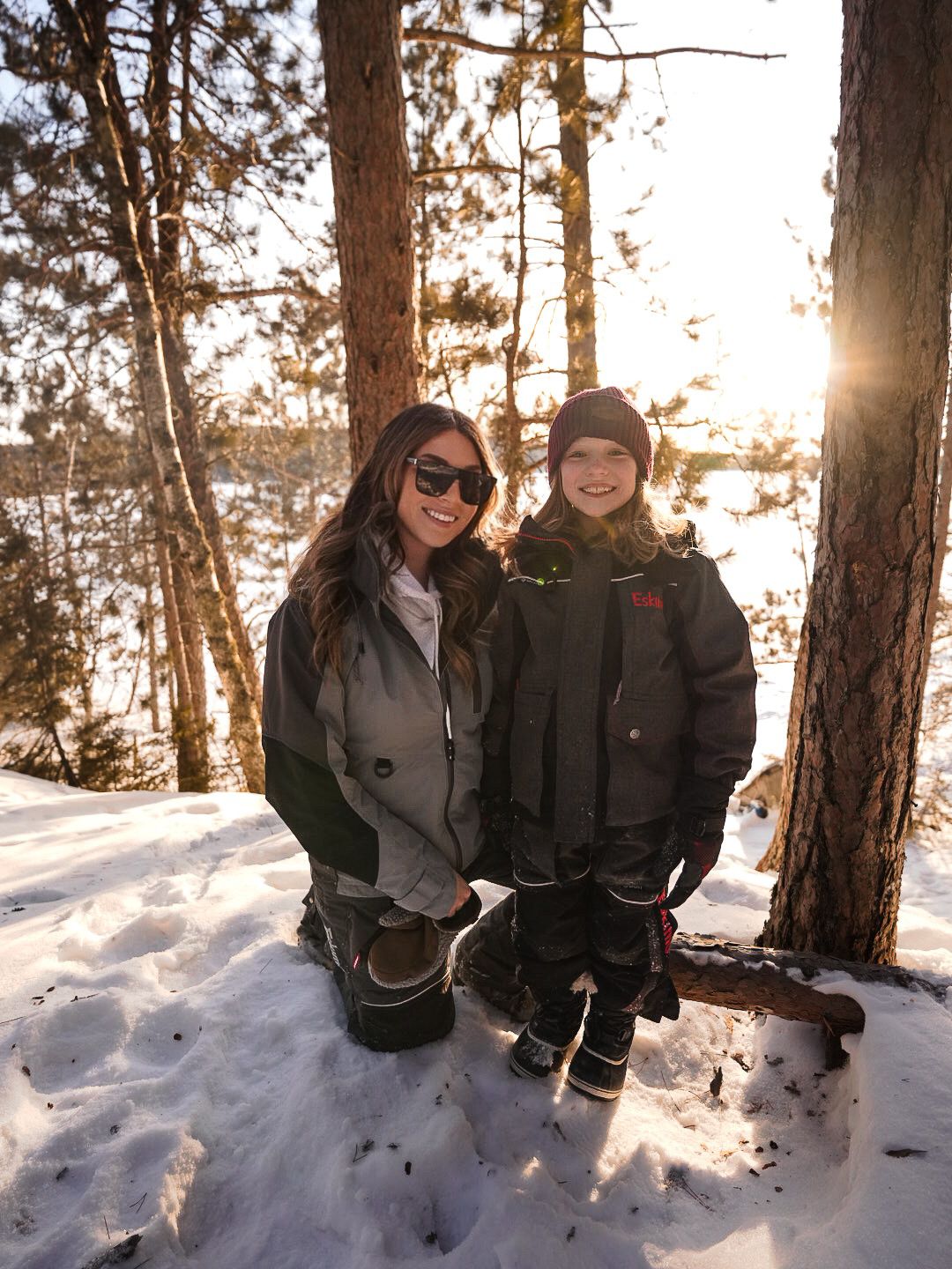 Group enjoying a winter day in the snowy forest wearing warm winter clothing.