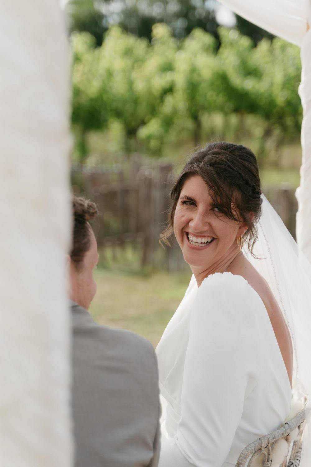 A joyful moment captured during outdoor wedding ceremony under white tent.