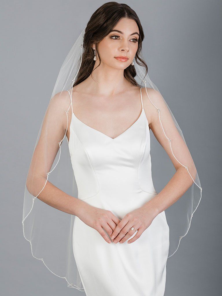 Simple elegant wedding dress with scalloped veil and spaghetti straps.