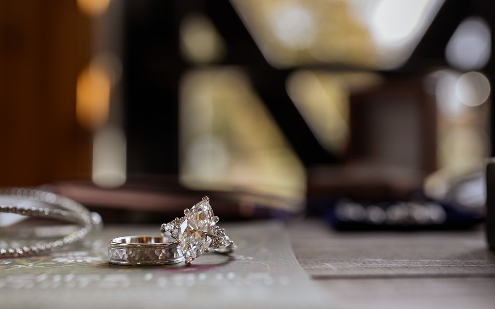 Close up macro shot of a sparkling diamond engagement ring with a blurred background.