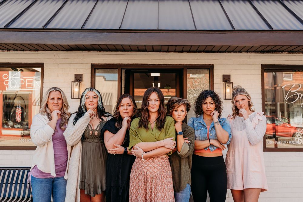 Group of hair stylist standing together in various outfits at an outdoor Brushed On Main Street Branding Headshots, Wayland MI