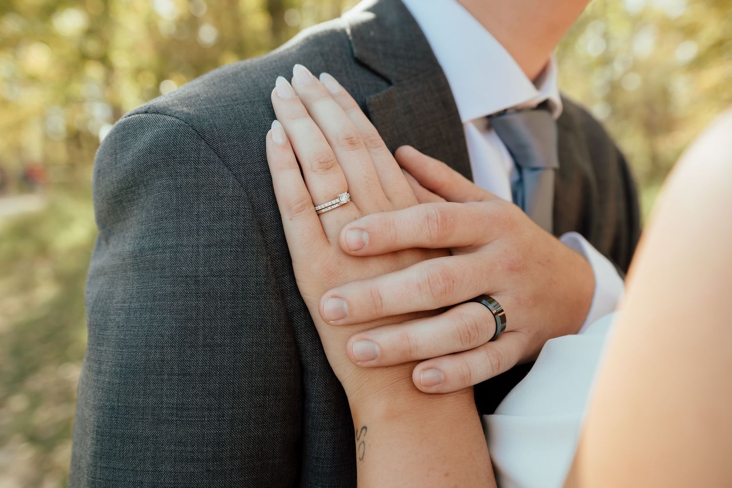 A wedding couple shares an intimate moment while standing together in a lush wooded garden setting.