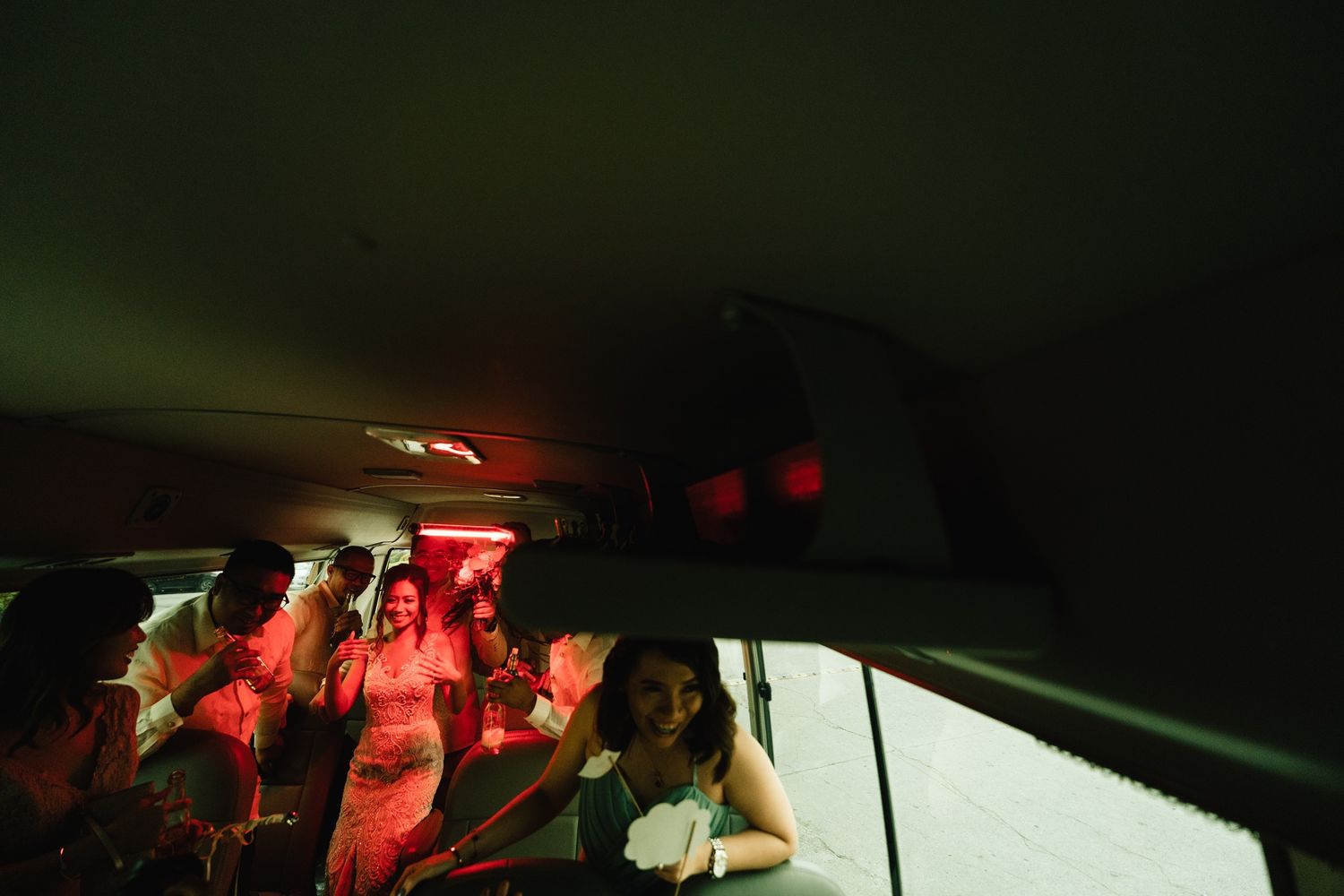 Interior of car with passengers bathed in atmospheric red lighting at night.