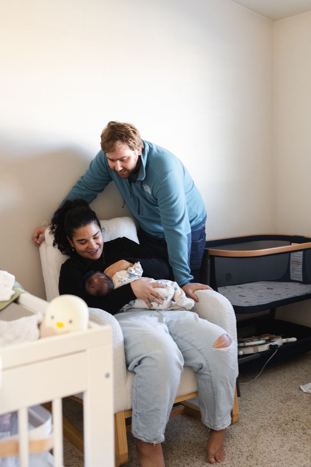 Series of intimate moments showing parents bonding with their newborn baby in a minimalist room setting.