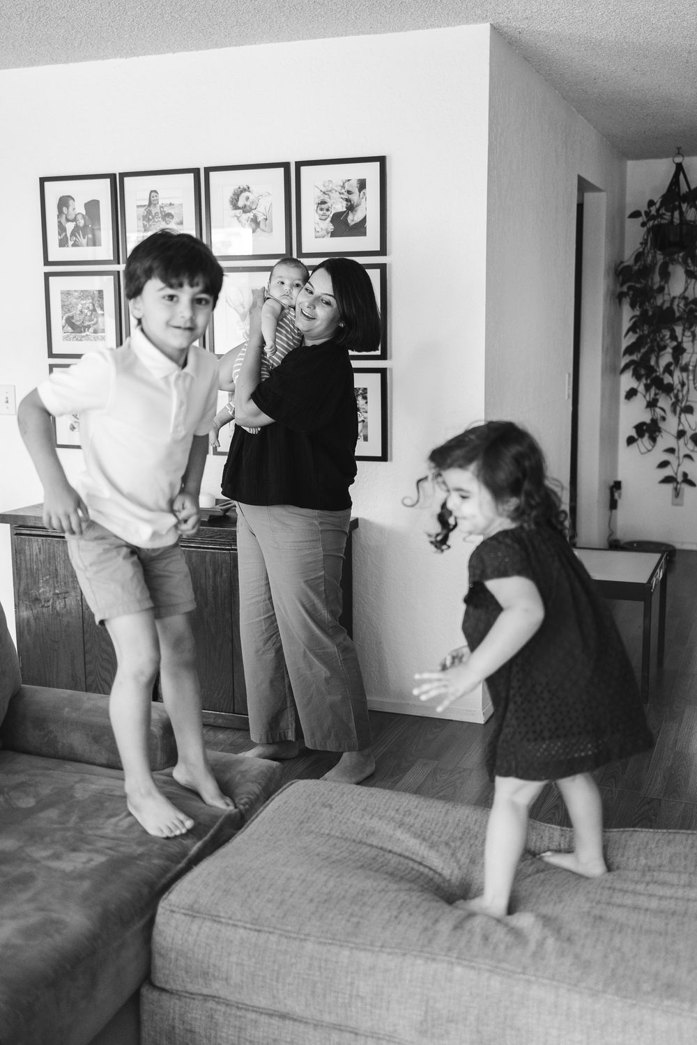 A sequence of black and white photos showing someone jumping on a couch in a living room with framed art on the wall.