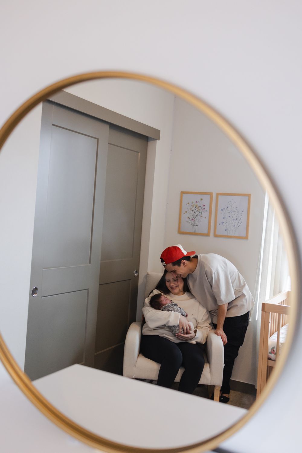 A sequence of mirror reflections showing two people in a minimalist white room with grey doors.