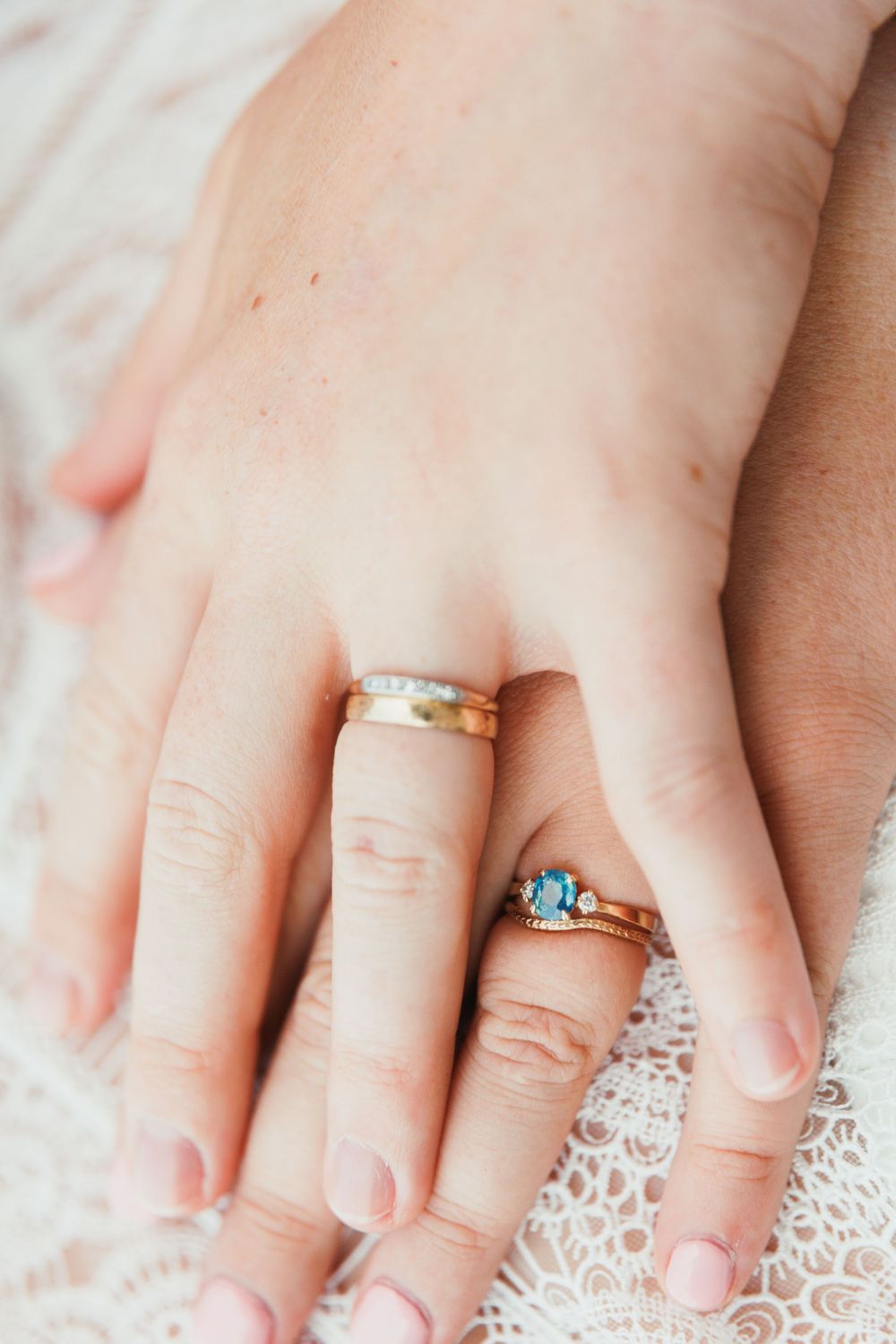 Close-up of wedding rings and delicate lace dress details.