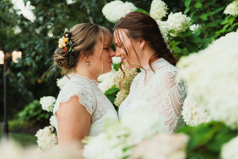 Intimate wedding moment captured among white hydrangea blooms.