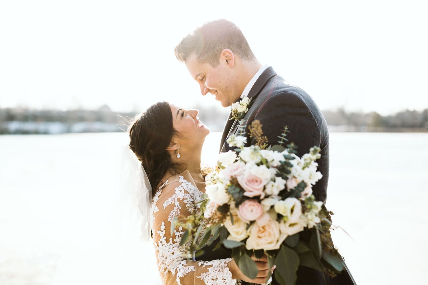 A couple shares an intimate moment during their wedding photoshoot at sunset.