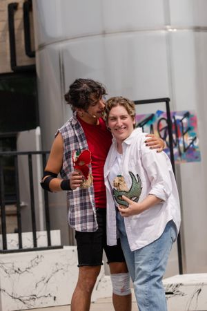 Two people embracing and smiling together outdoors in casual attire near a graffiti wall.