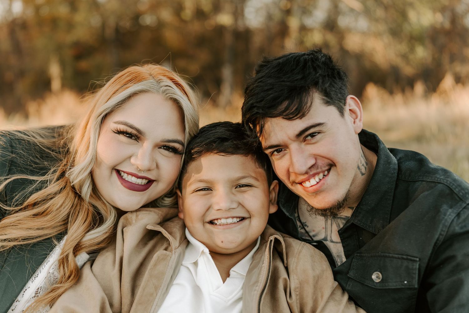 Close up family photo showing joyful smiles against a warm autumn background.