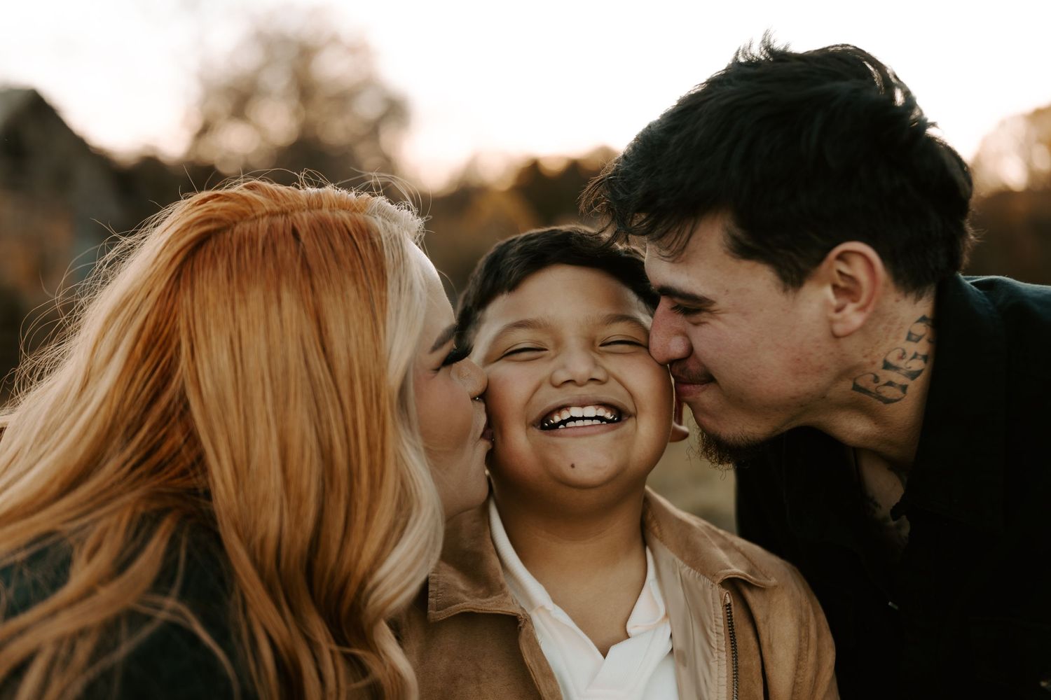 Candid moment of family affection and laughter captured in golden hour lighting.