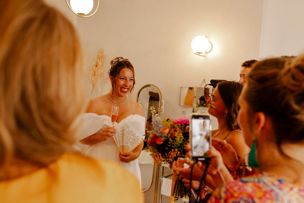 Mariée avec une coupe de champagne et ses amies