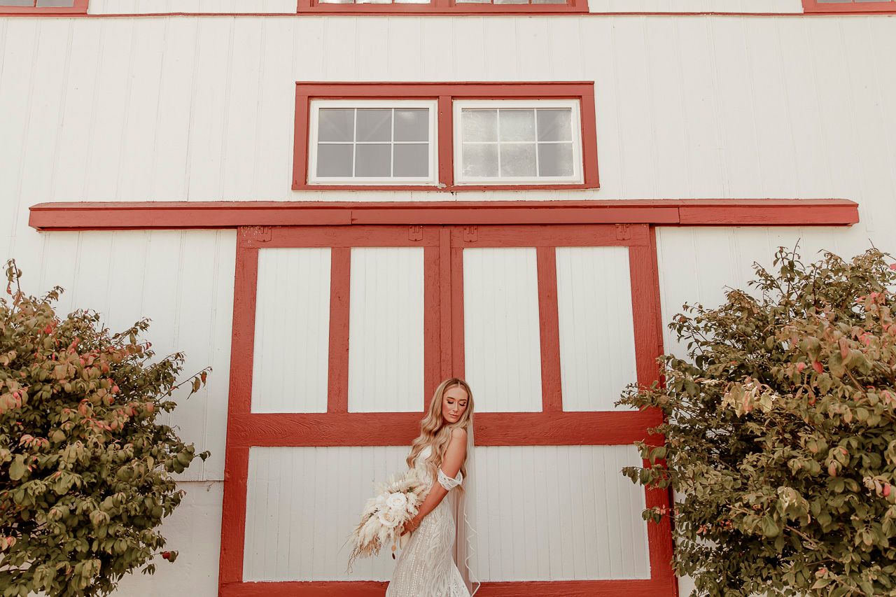 Rustic red and white building exterior with Tudor-style architectural details and green bushes framing the entrance.