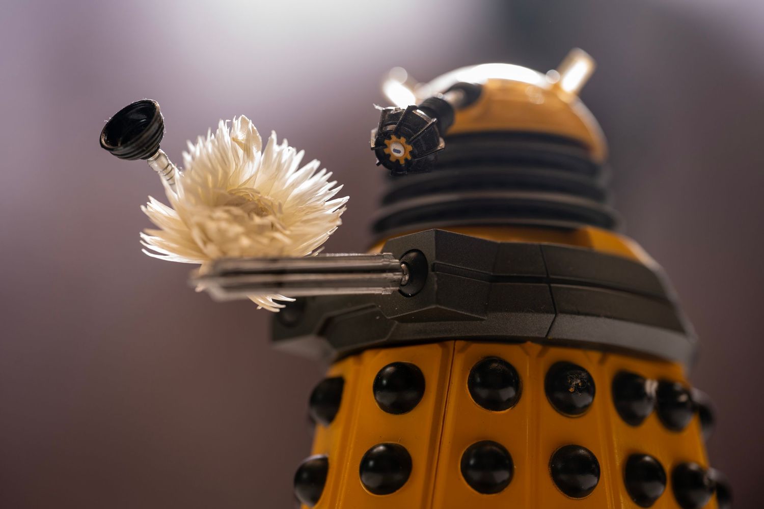 A collection of yellow and black Dalek toy figurines from Doctor Who shown in a repeating pattern.