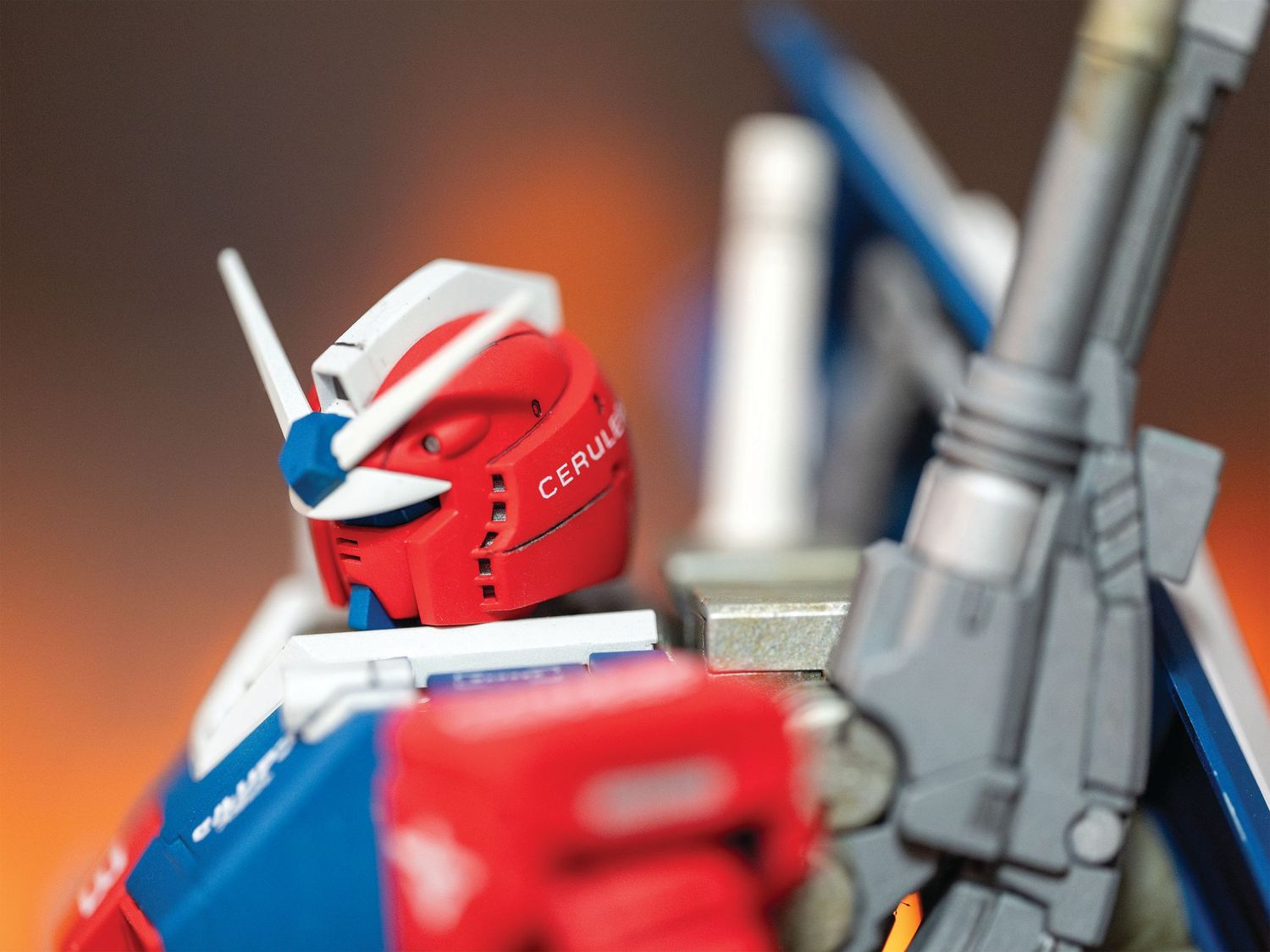 A close-up sequence of a red and white Gundam model kit being assembled, showing detailed mechanical parts and joints.