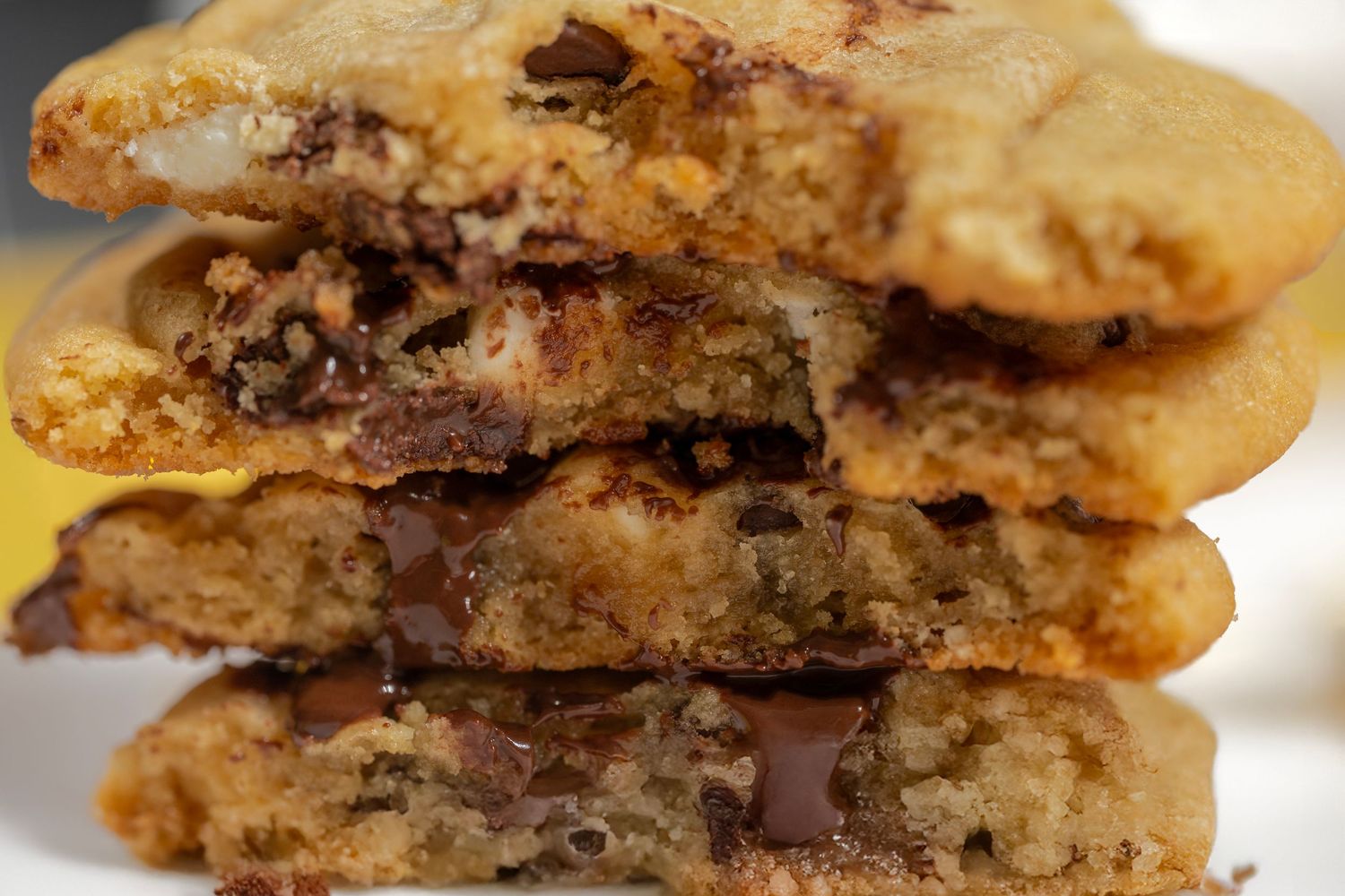 Close-up shots of chocolate chip cookies broken in half showing gooey melted chocolate chunks inside.