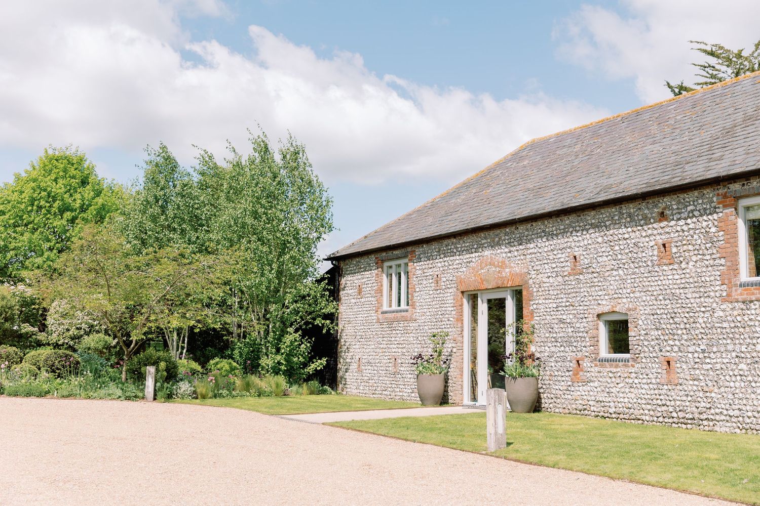 A rustic stone barn conversion with brick walls and wooden door set in a peaceful countryside setting at Farbridge by Maddie Waters