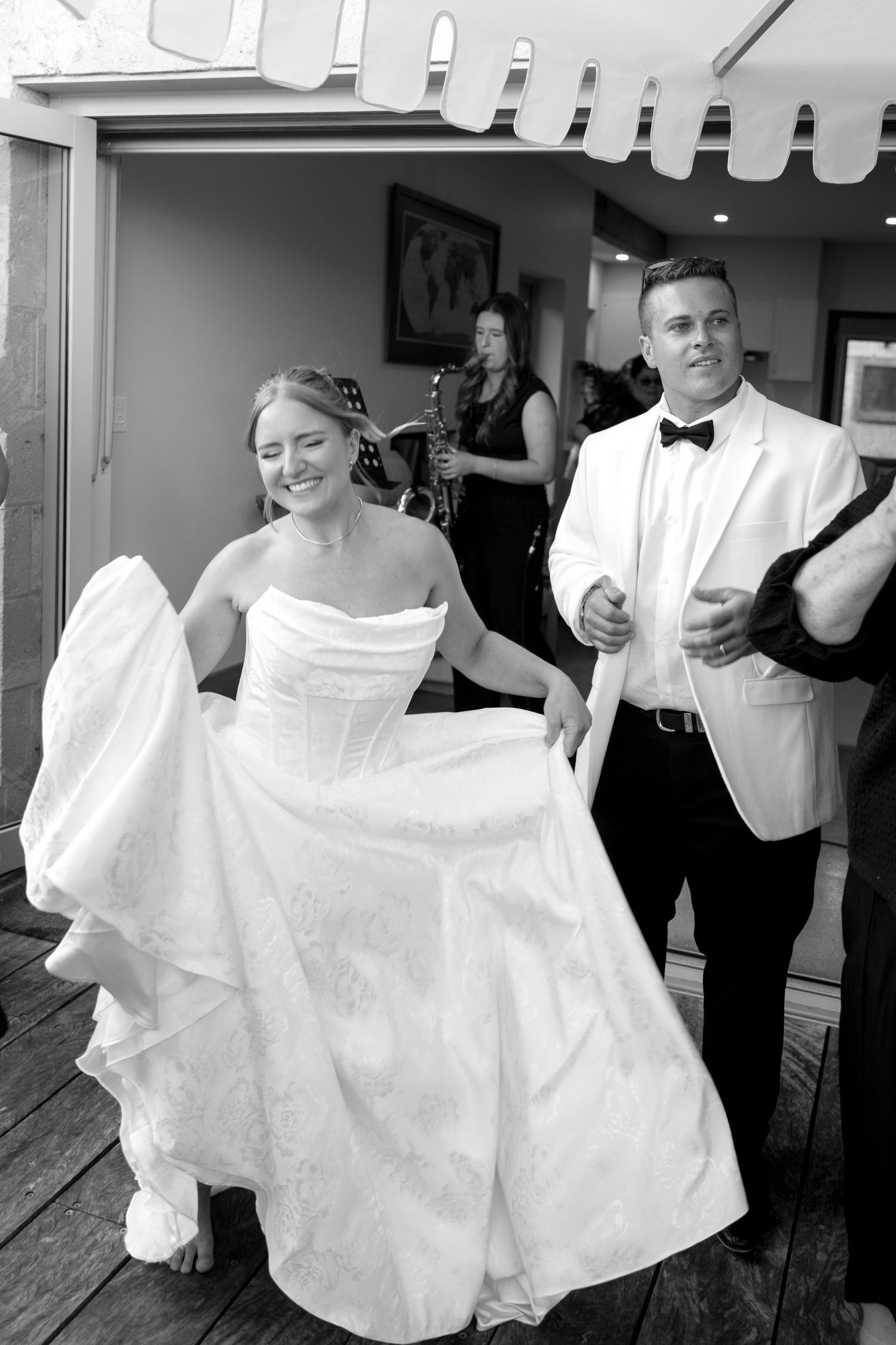 A couple dances and twirls on a wooden deck during their wedding celebration.