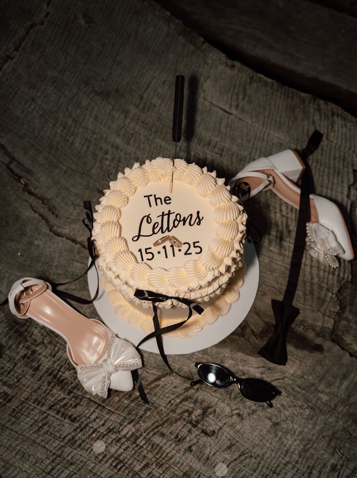 Wedding shoes and accessories arranged artistically on wooden surface.