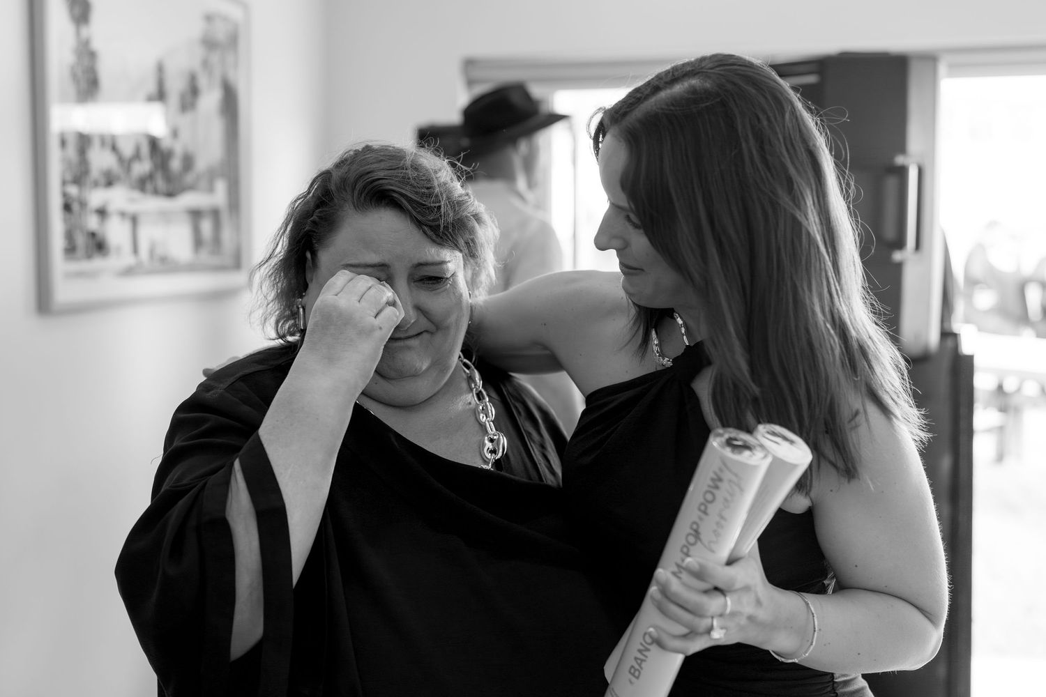 A group of people dancing and embracing at a social gathering in black and white photography.