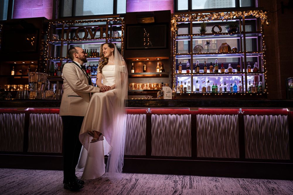 Elegant reception venue with illuminated bar area and purple mood lighting creating a romantic atmosphere.