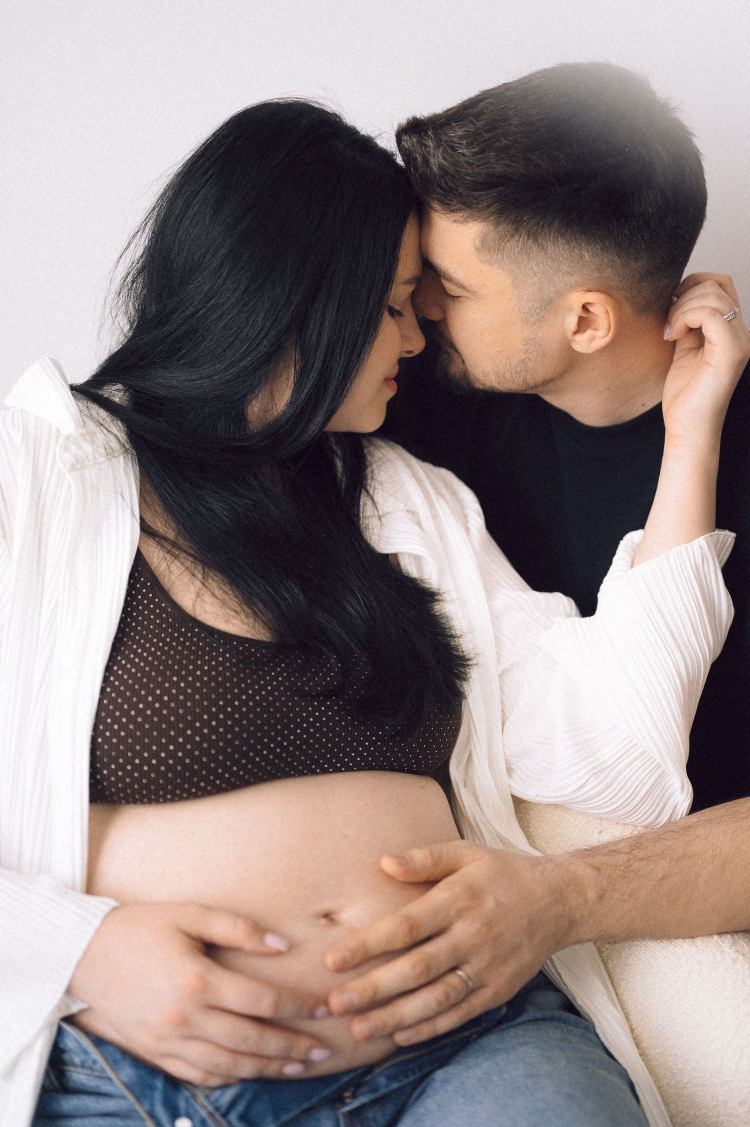 Intimate maternity photography sequence showing tender moments between couple on white background.