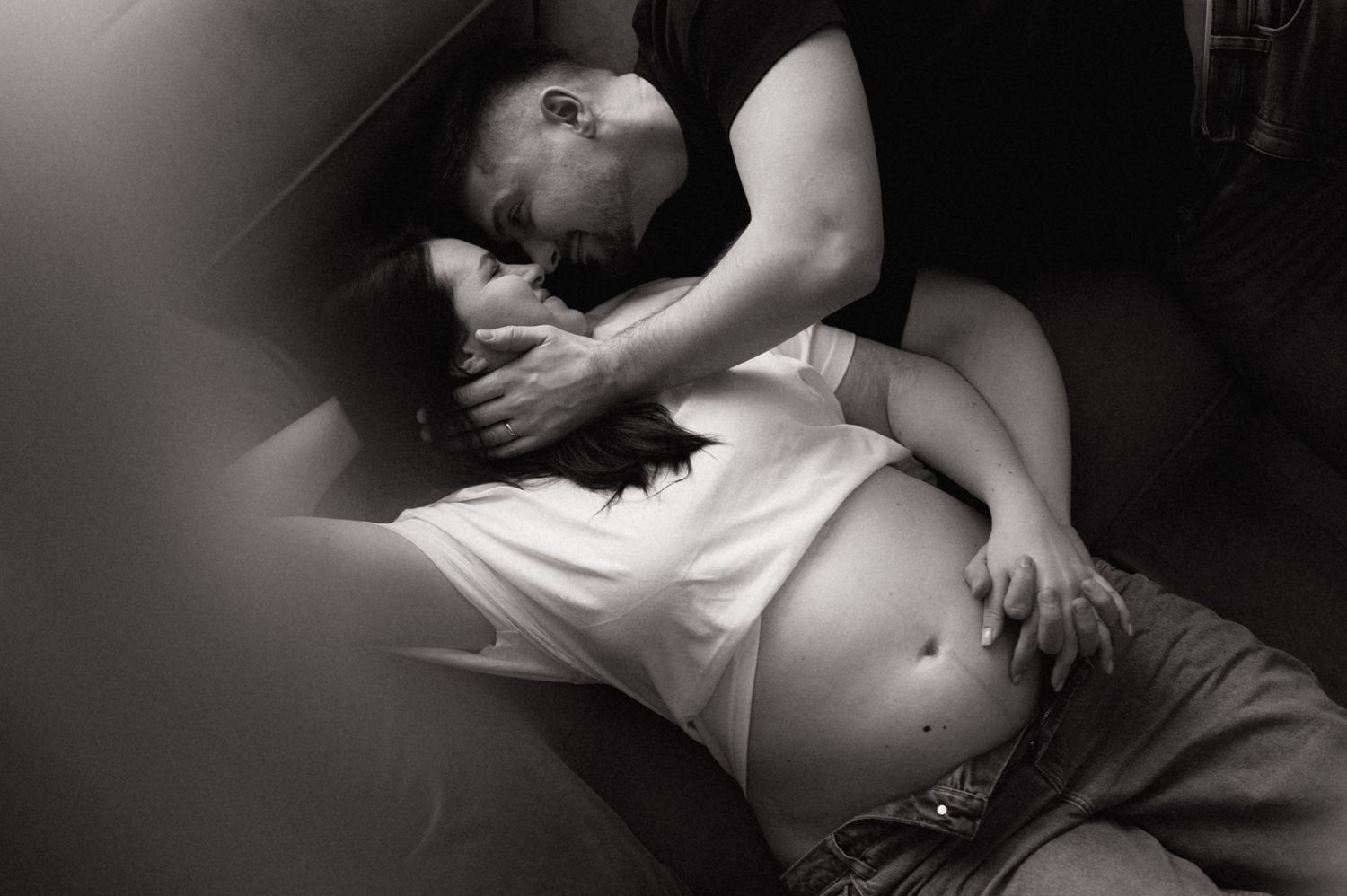 Monochromatic artistic portrait showing someone lying down in dramatic lighting and shadows.