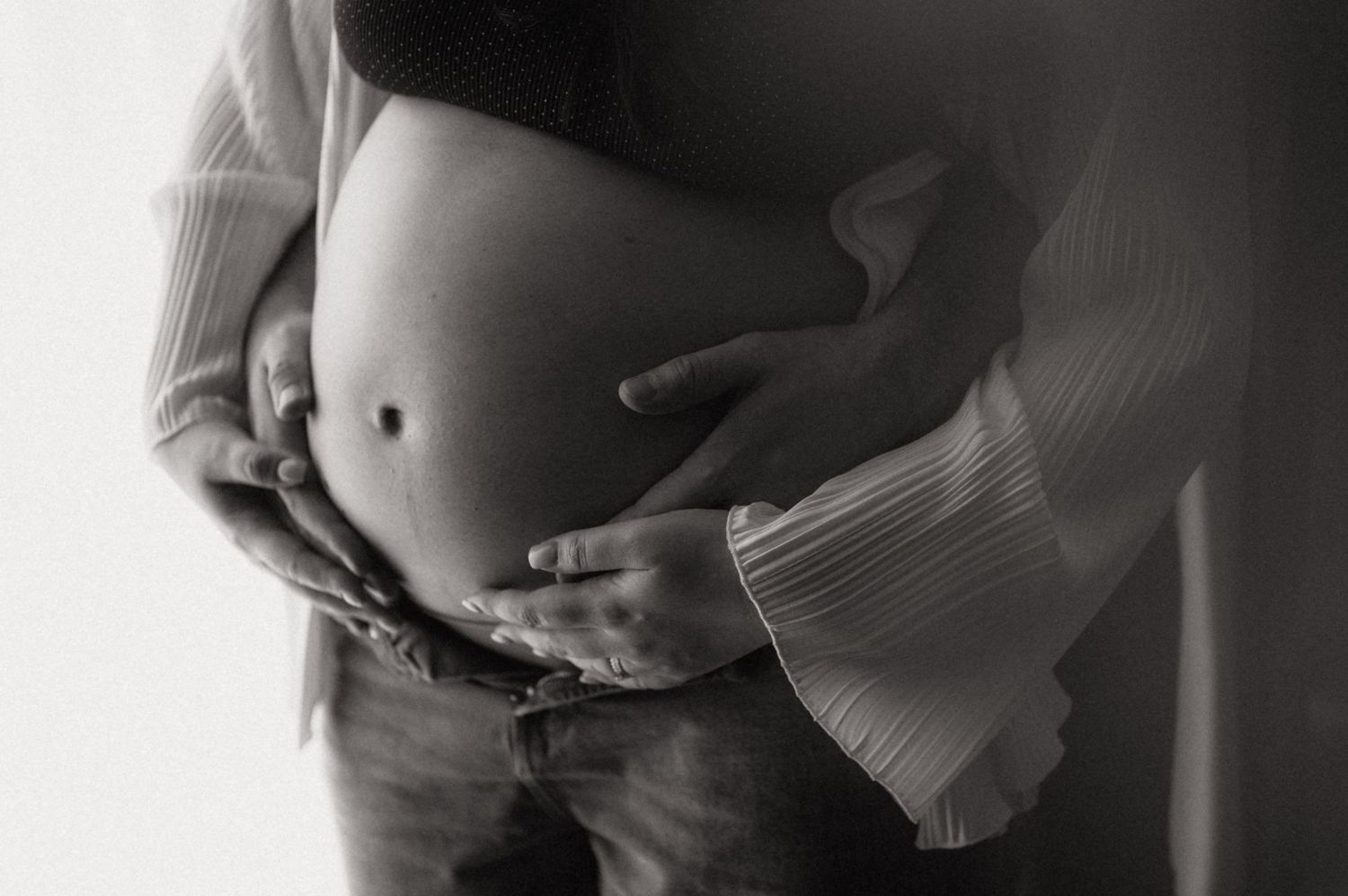 Series of romantic maternity portraits showing couple's silhouettes in monochrome lighting.