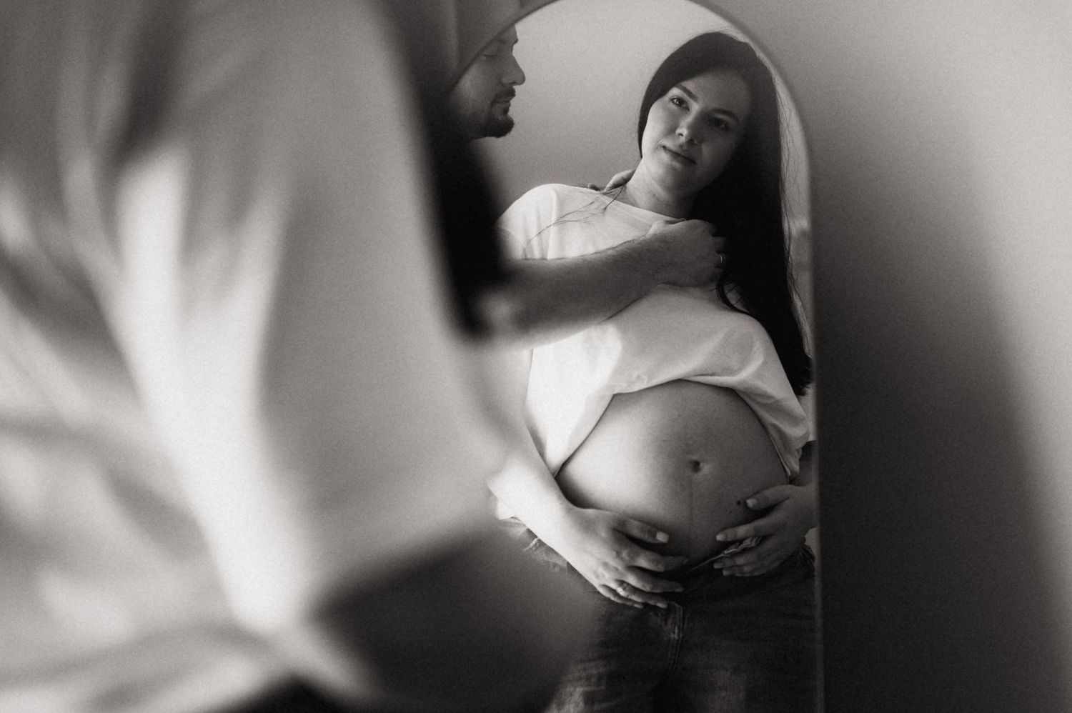 Black and white artistic maternity photo series showing pregnant woman's belly in various intimate poses.
