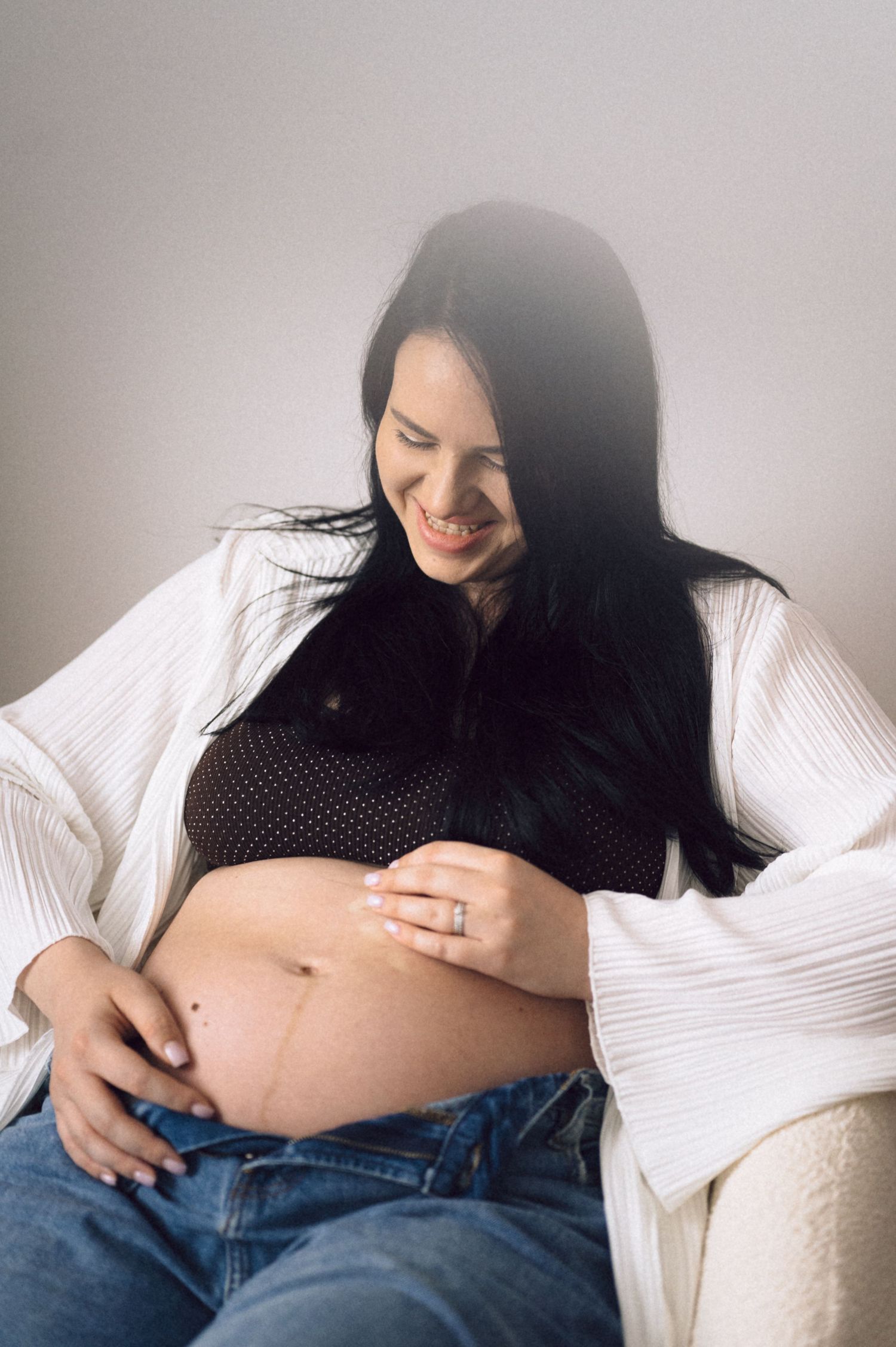 A pregnancy photo series showing a pregnant belly with hands gently resting on it in various poses.